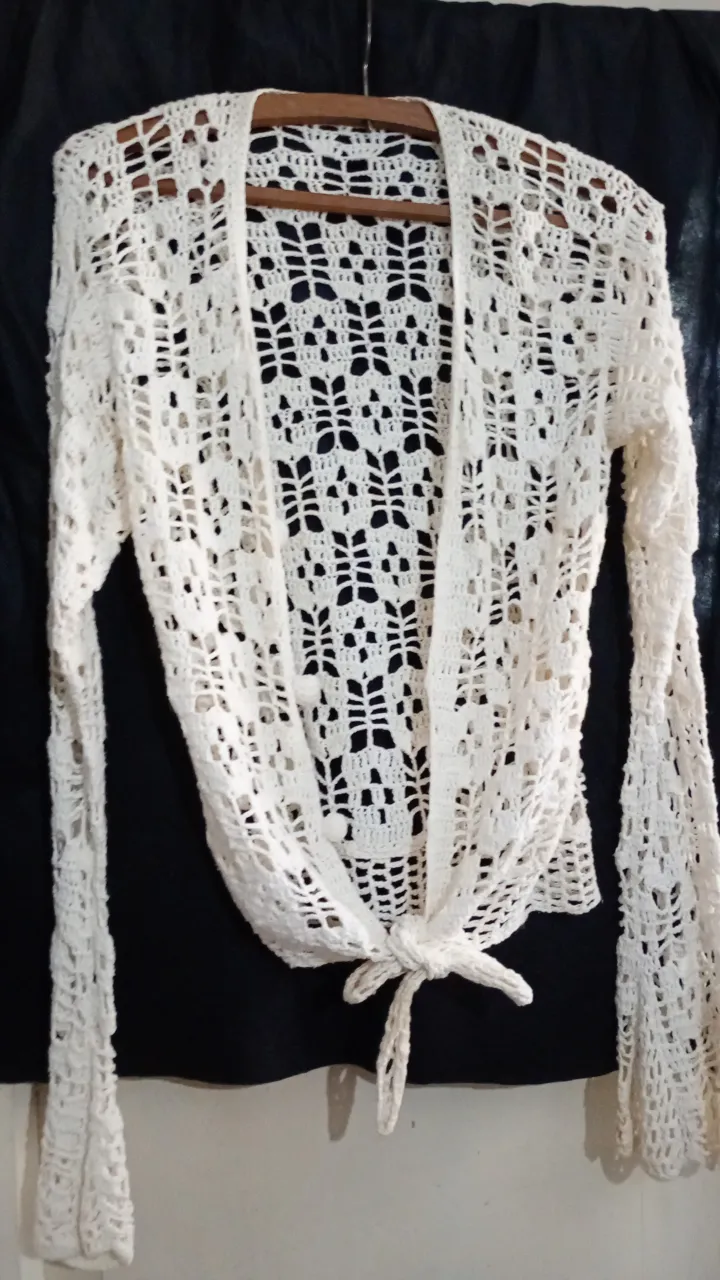 Cardigan de crochet blanco, tejido artesanal con diseño calado. Ideal para un look bohemio y fresco.