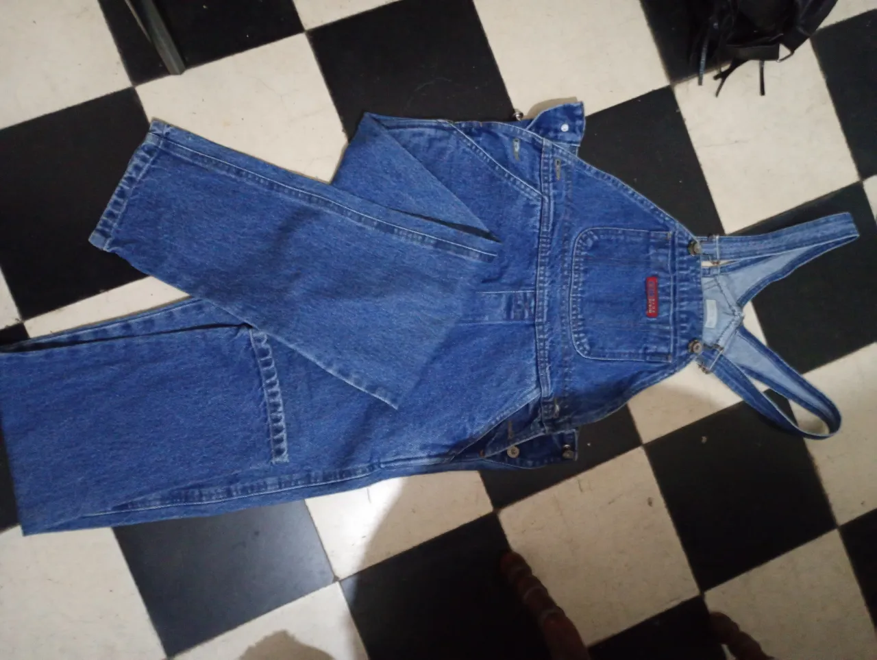 Overol de jean azul, con bolsillos delanteros y traseros. Ideal para un look casual y cómodo.