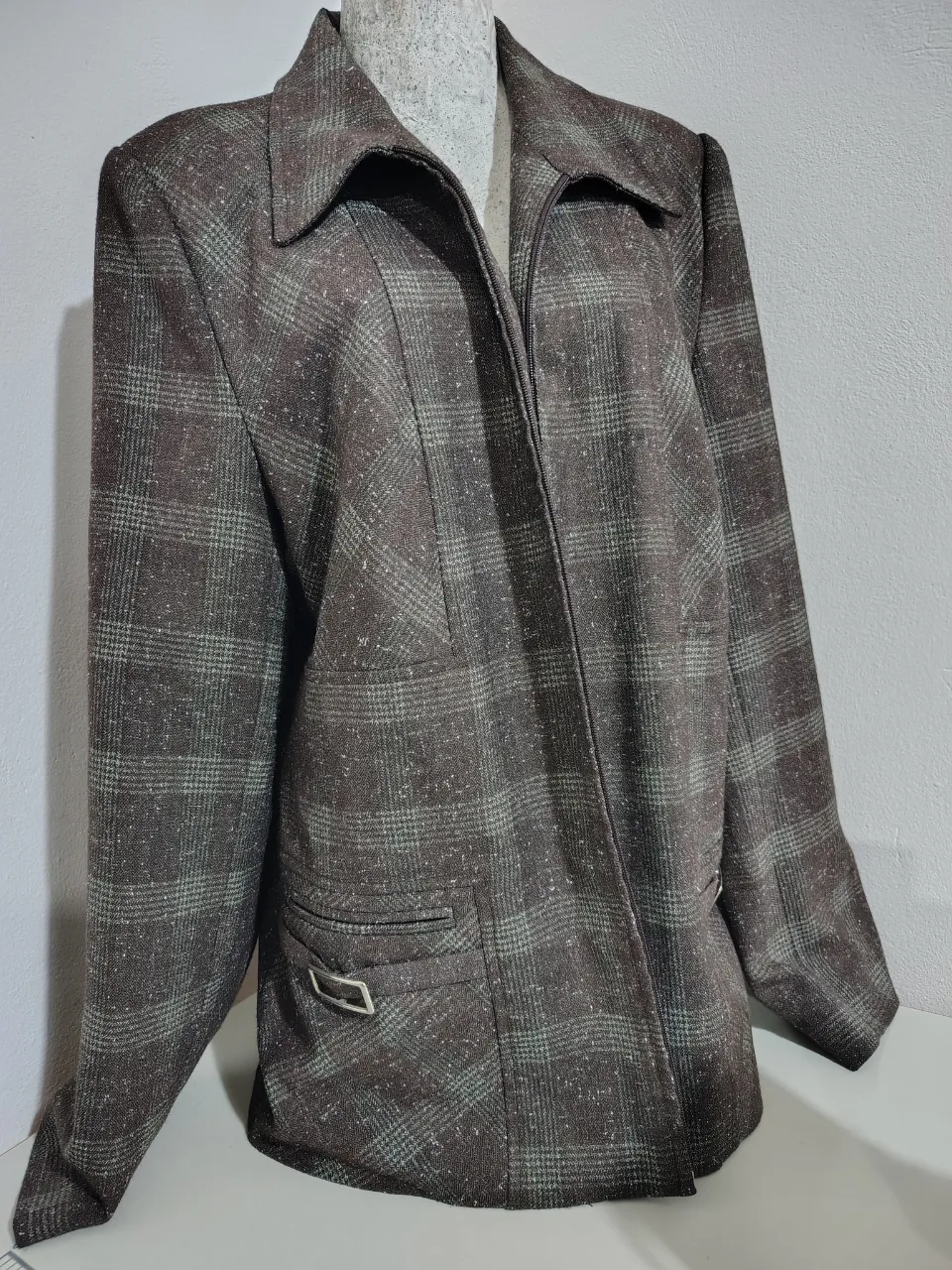 Blazer a cuadros de corte clásico, ideal para un look elegante y sofisticado. Perfecto para combinar con pantalones de vestir o jeans para un estilo más casual.