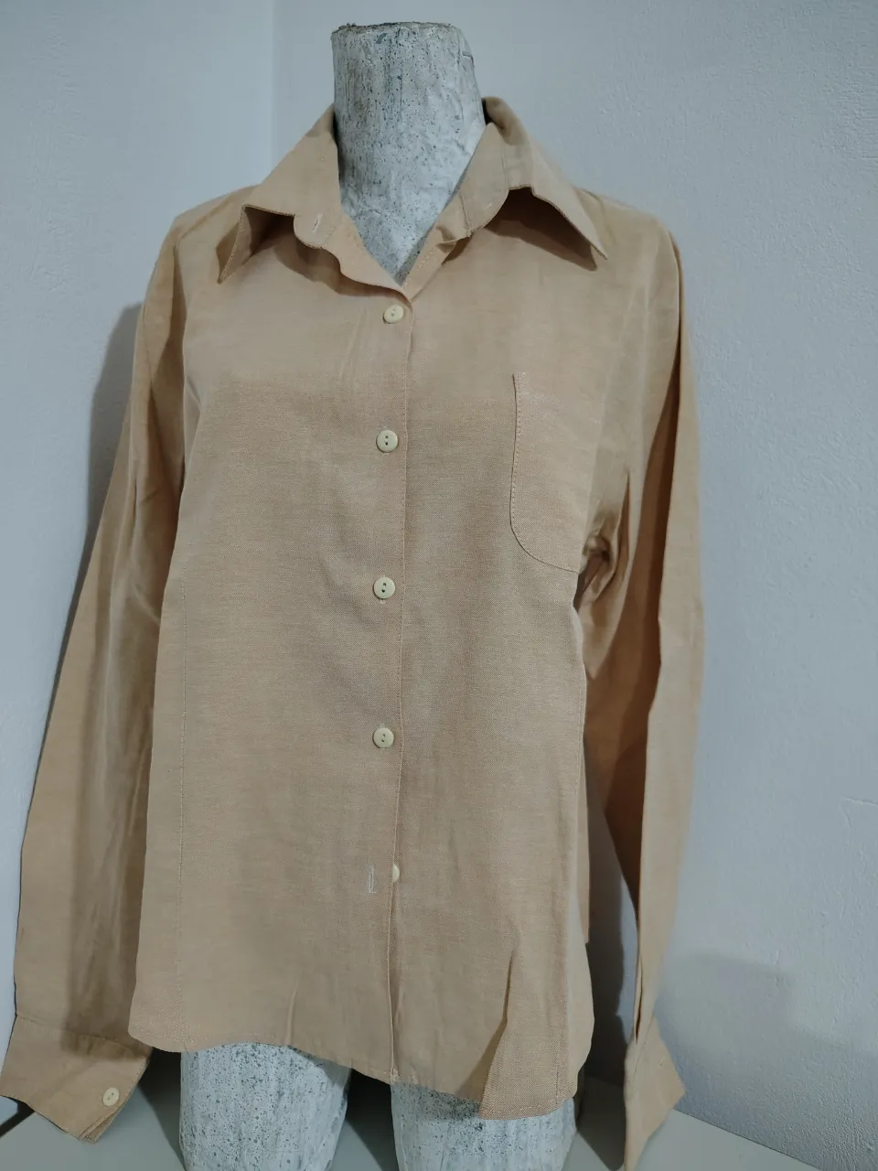 Camisa de lino color tiza, manga larga, con botones al frente y un bolsillo en el pecho. Un básico atemporal para cualquier guardarropas.