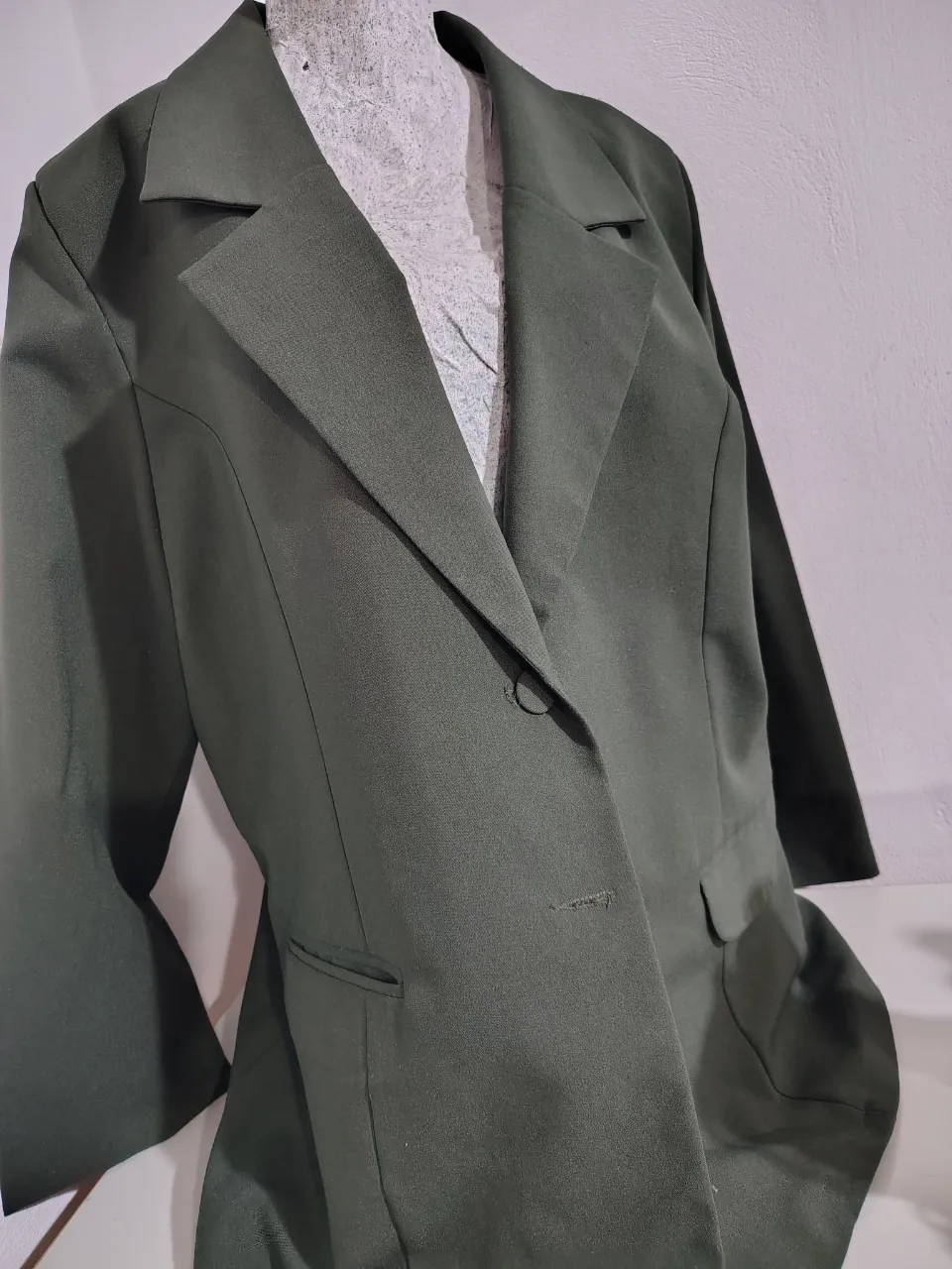 Blazer de vestir color verde oscuro, ideal para un look elegante y sofisticado. Perfecto para eventos formales o para darle un toque chic a tu outfit de trabajo.