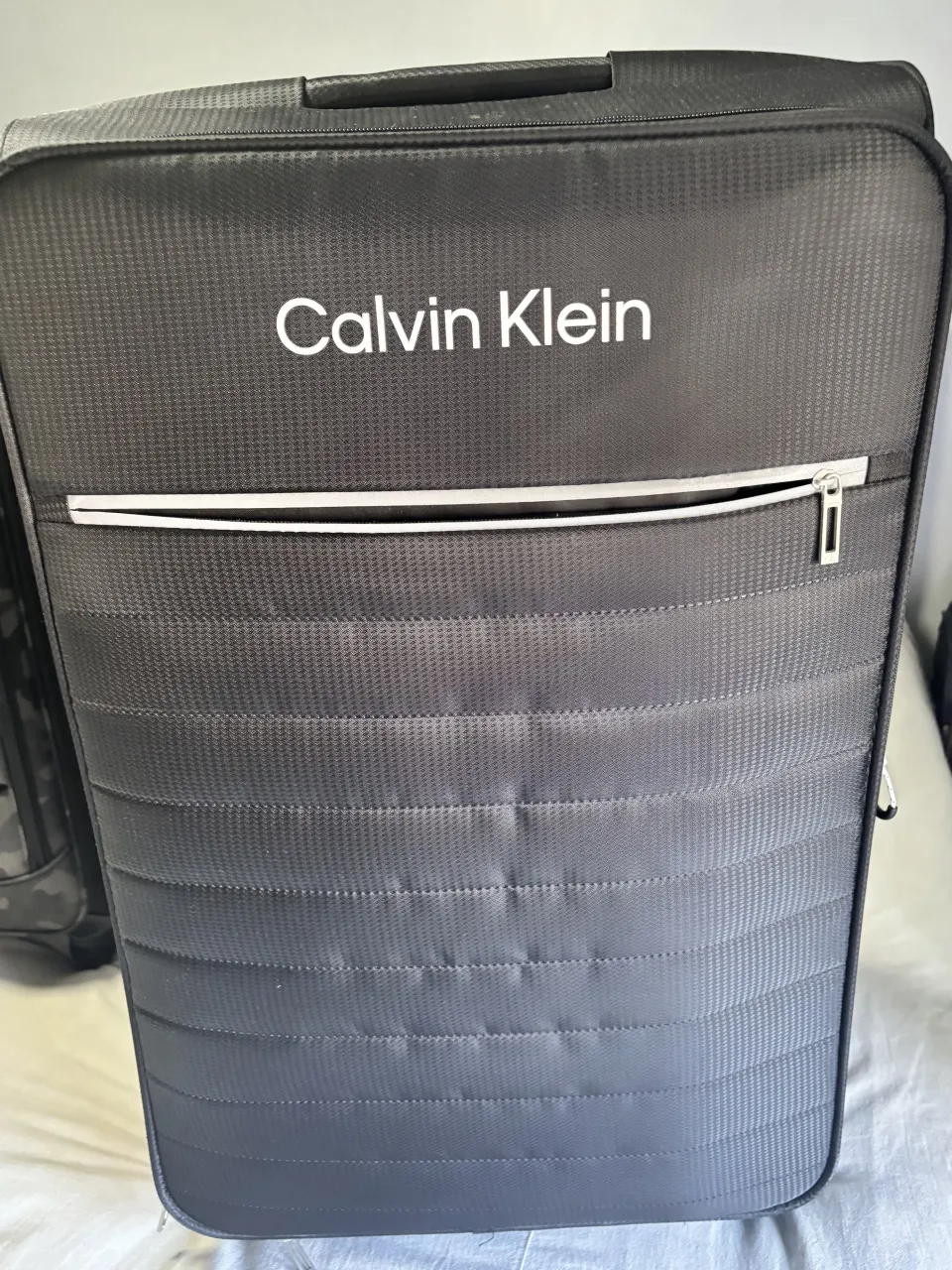 Valija de cabina negra de la marca  calvin klein Diseño moderno y funcional con bolsillo frontal con cierre y ruedas para facilitar el traslado. 88 cm de alto
