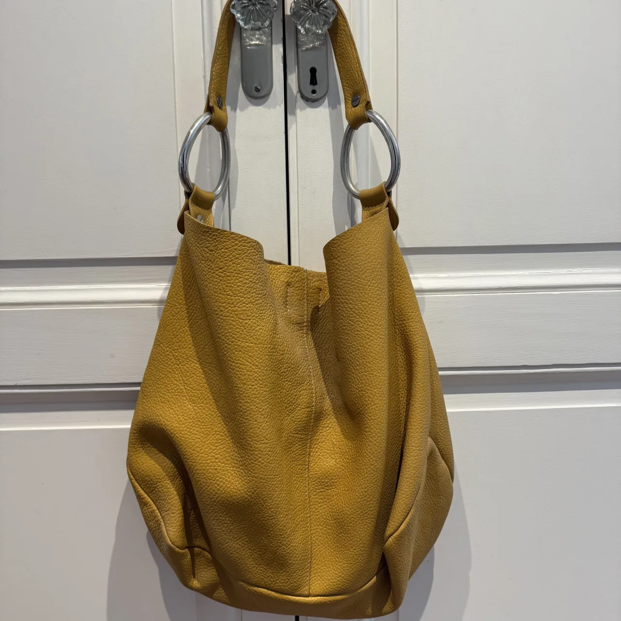Bolso amarillo de cuero con detalles plateados. Ideal para el día a día o para darle un toque chic a tu outfit.