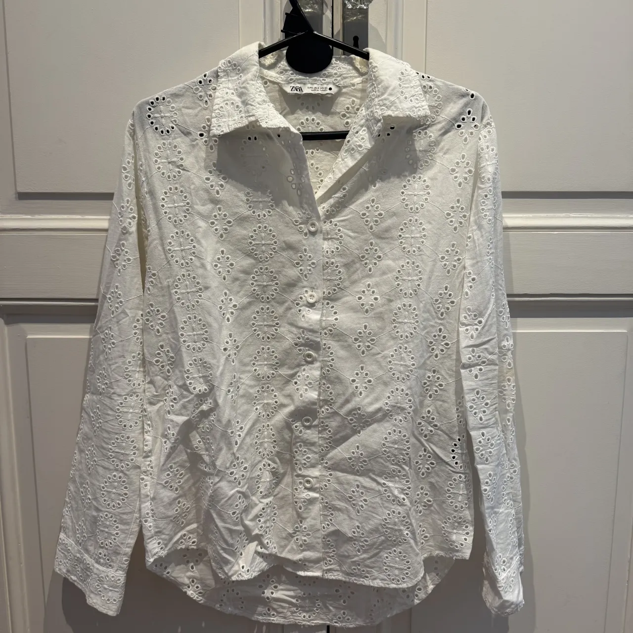 Camisa blanca de lino con bordados florales y detalles de puntilla. Manga larga, cuello camisero y botones al frente. Perfecta para un look fresco y romántico.  tiene una manchita q se ve en la última foto