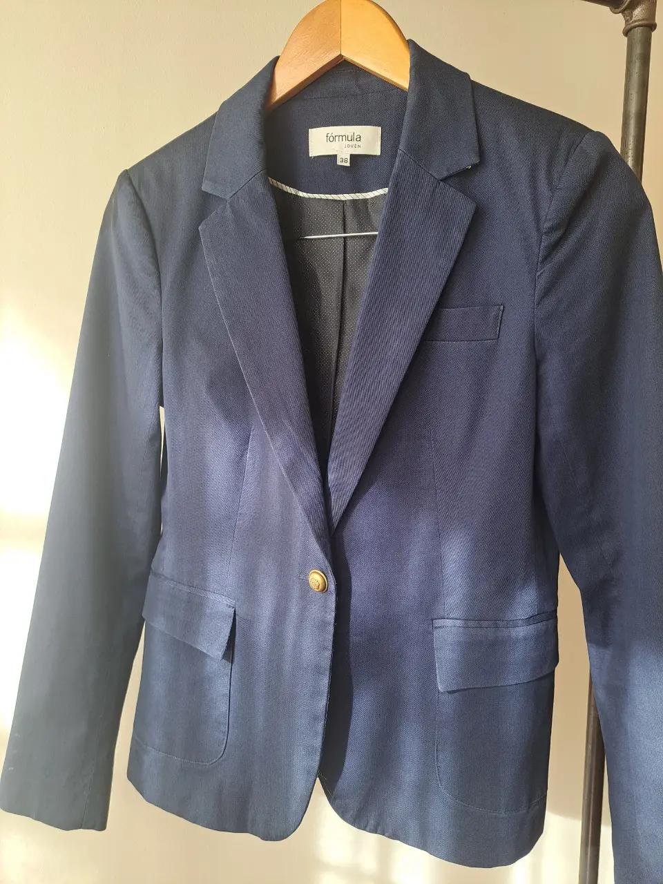 Blazer de mujer azul marino, con un botón dorado y forro interior. Ideal para un look formal o de trabajo.
