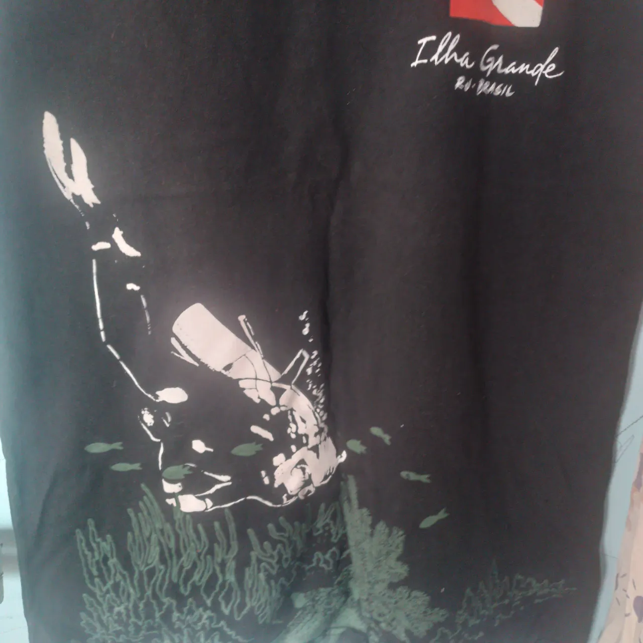 Musculosa negra con estampa de buzo y "Ilha Grande RJ-BRASIL" en la parte superior. Ideal para un look casual y playero.