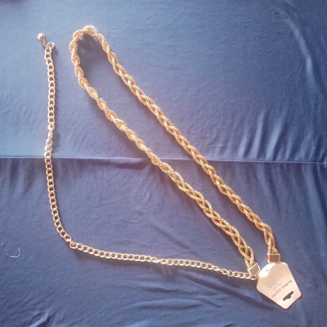 Cadena dorada para cinturón, con eslabones trenzados y detalle de cadena fina. Ideal para complementar cualquier outfit y darle un toque de brillo.