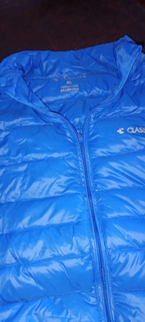 Chaleco turquesa de matelase con cierre completo al frente. Tiene cuello mao y logo de la marca bordado en el pecho.Tiene plumas y prácticamente sin uso,hiperliviano y suave 