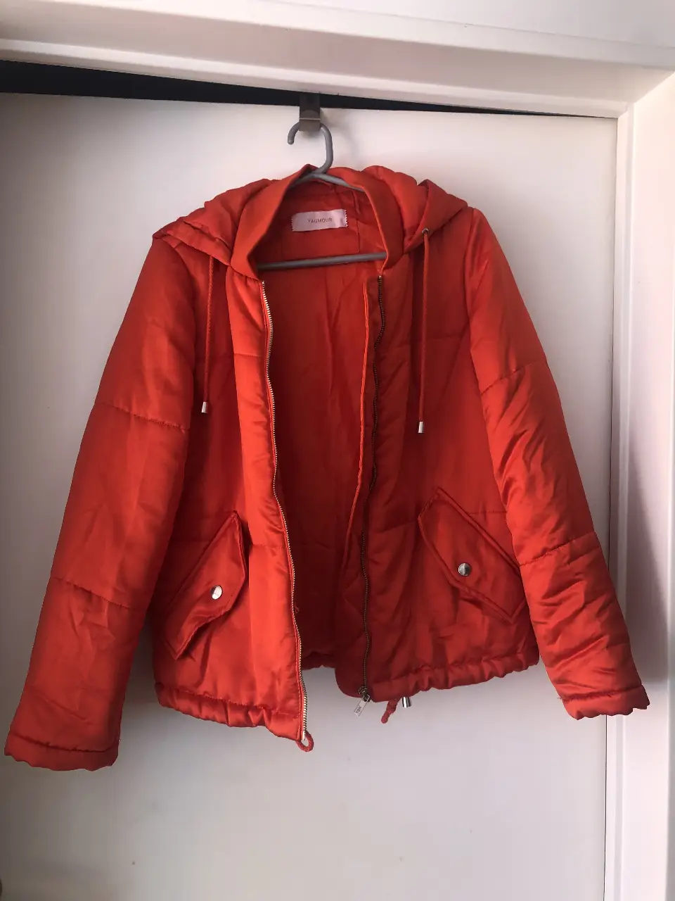 Campera roja con capucha, cierre y bolsillos. La tela es satinada y suave. Tiene algunos pequeños degastes en la tela, no son muy obvios a la vista. Ideal para un look casual y abrigado.