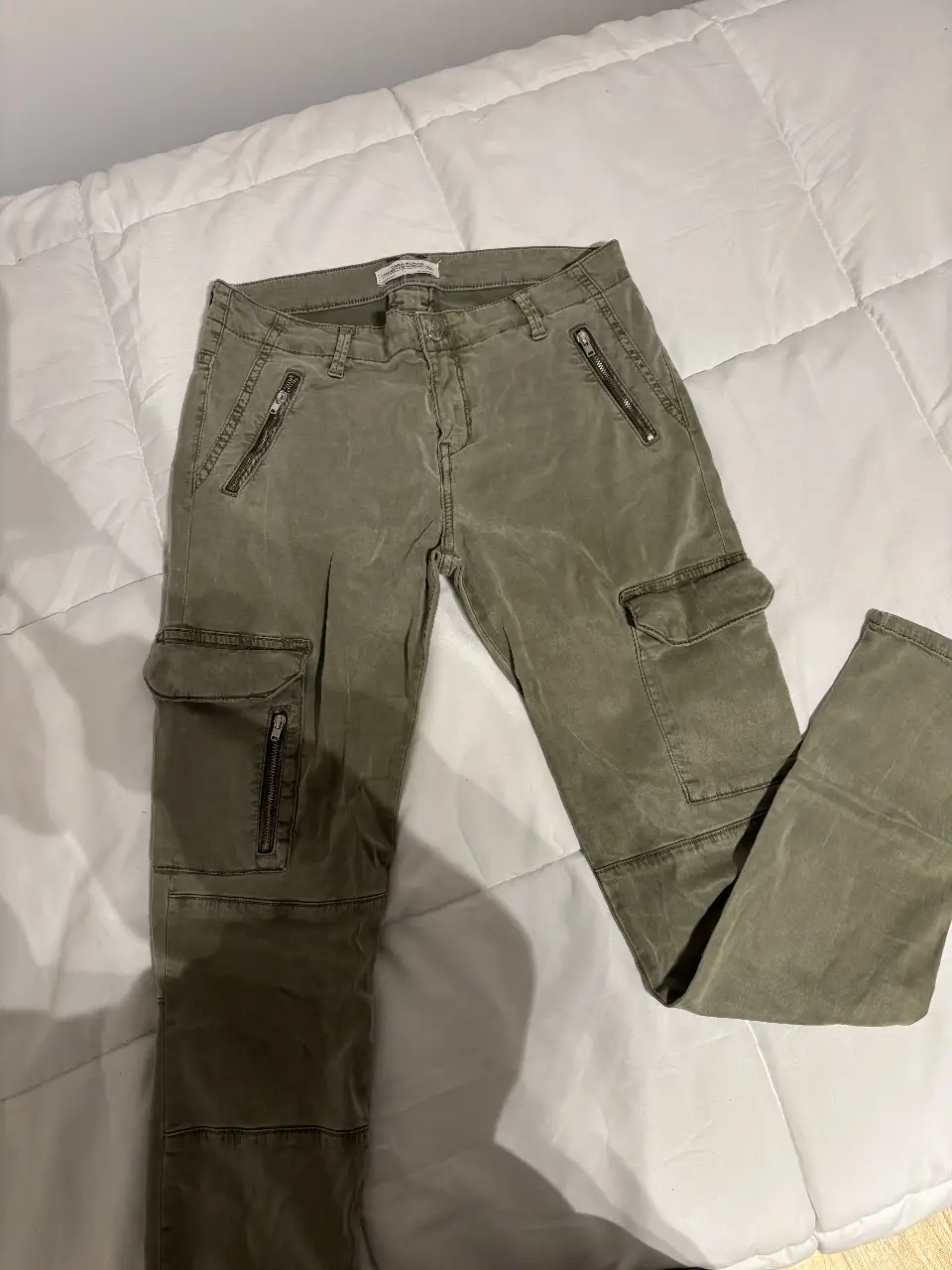 Pantalón cargo de mujer, color verde militar. Con bolsillos laterales y detalles de cierres. Marca Zara. tiro bajo