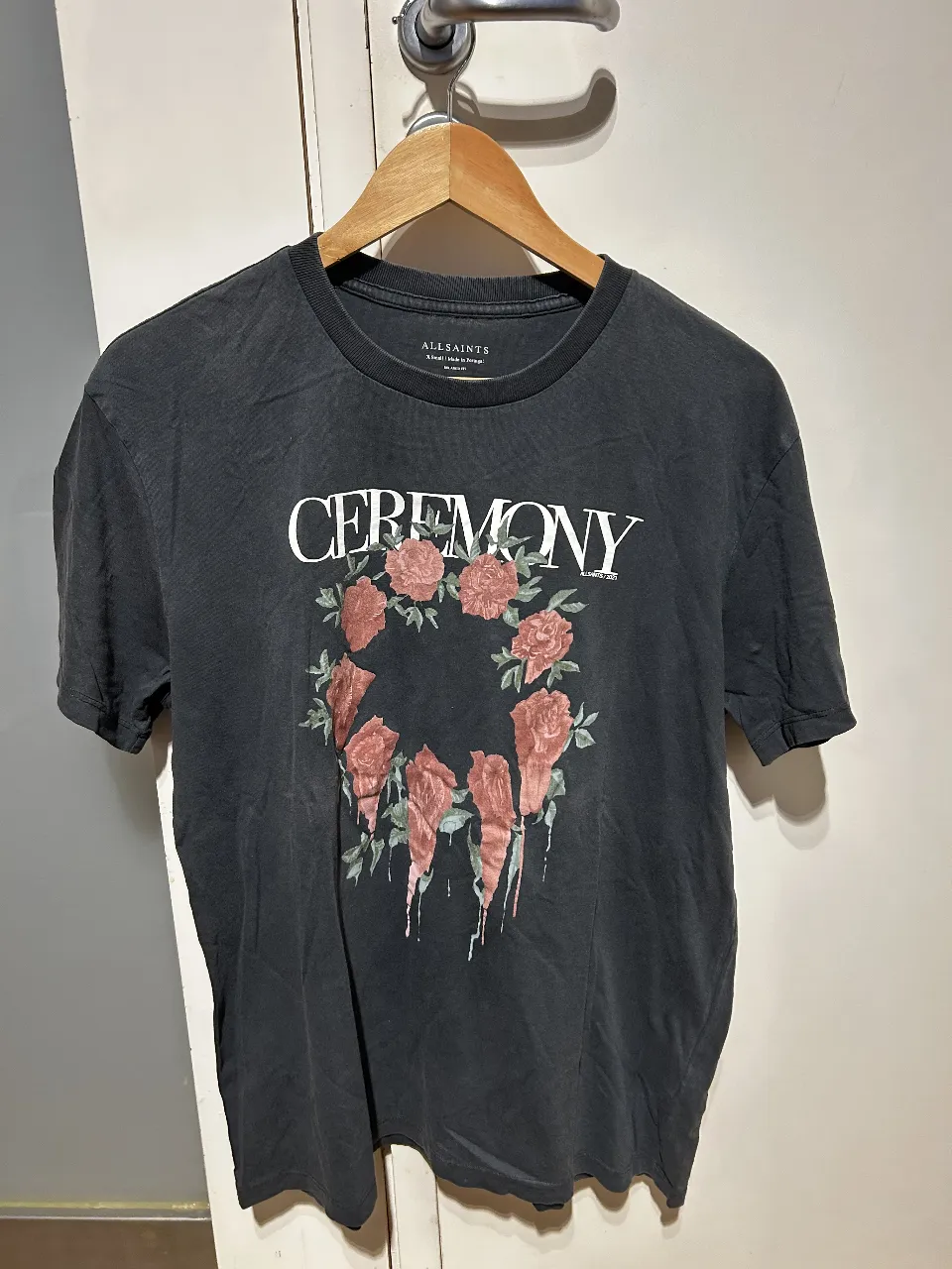 Remera negra de algodón con estampado floral "Ceremony" de la marca AllSaints. Corte clásico, talle pequeño.
