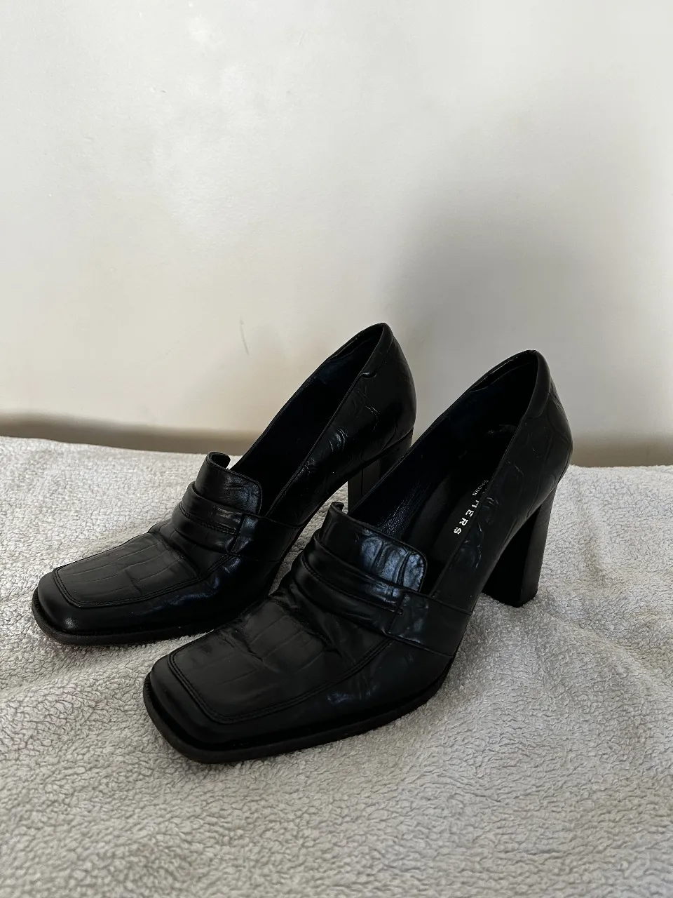 Zapatos de taco alto negros con diseño de cocodrilo. Ideales para un look elegante y sofisticado.
