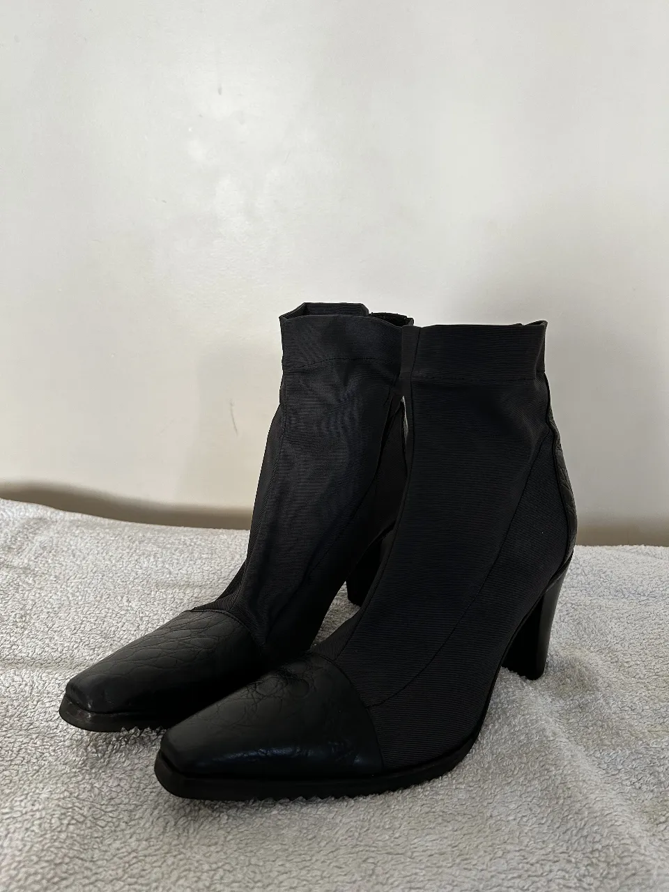 Botines negros de cuero con taco alto y punta cuadrada. Diseño elegante y moderno, ideales para complementar cualquier outfit.