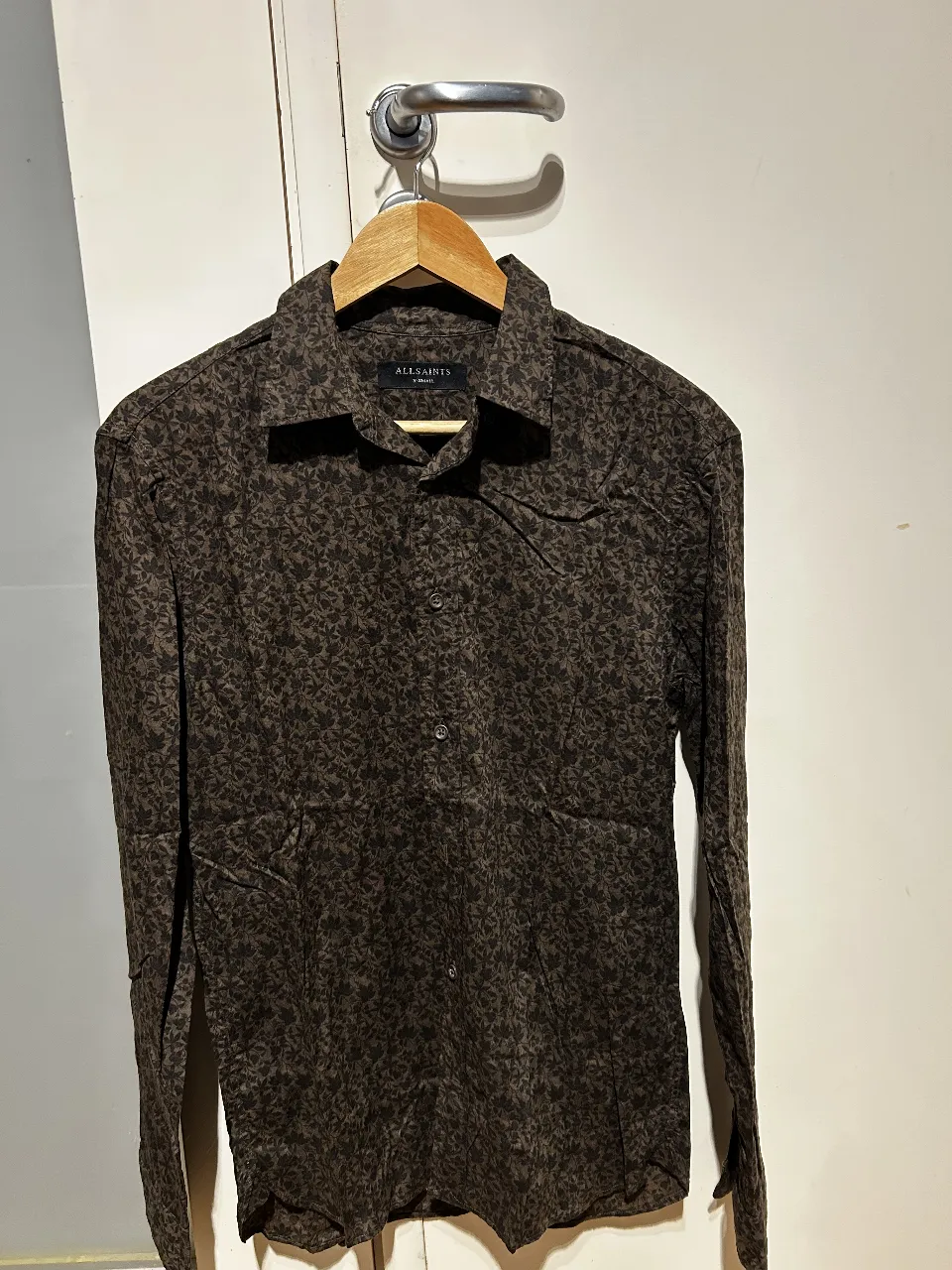 Camisa All Saints de hombre, manga larga, con estampado floral en tonos marrones. Talle XS. Ideal para un look casual y moderno.