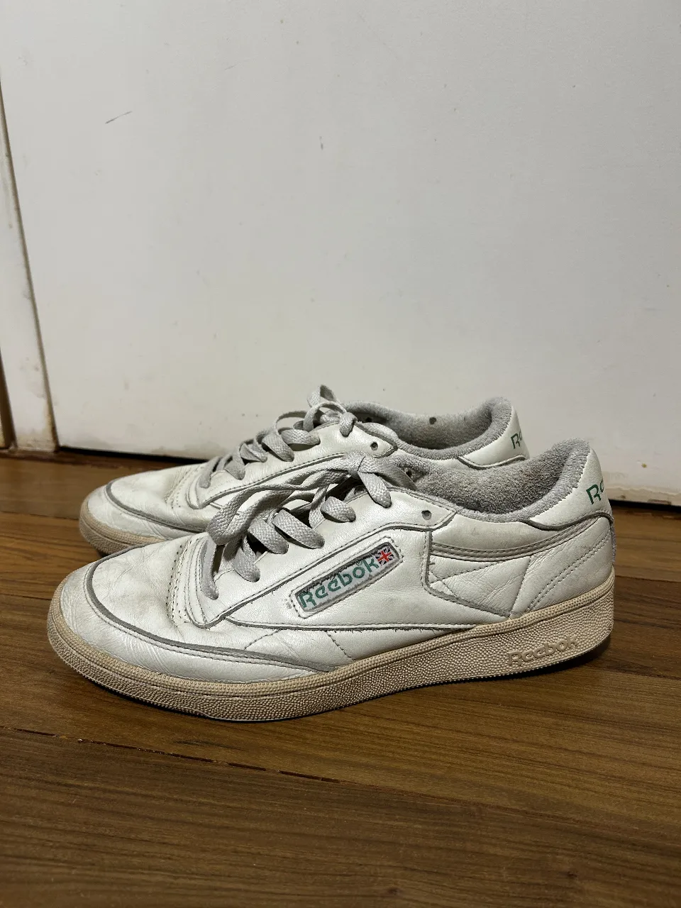 Zapatillas Reebok Club C 85 blancas, con detalles en verde y suela beige. Estilo vintage, ideales para un look casual y cómodo.