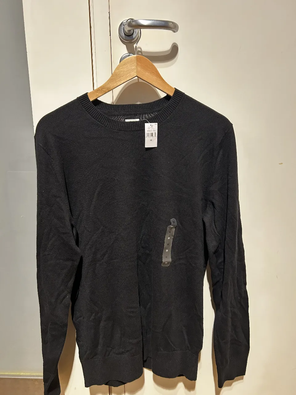 Sweater negro de hombre, de cuello redondo y manga larga. Ideal para un look casual y versátil.