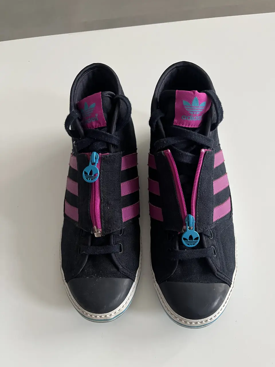 Zapatillas Adidas de caña alta para mujer, con cierre frontal y detalles en rosa y celeste. Talle 9.5 US. Estilo retro y deportivo.
