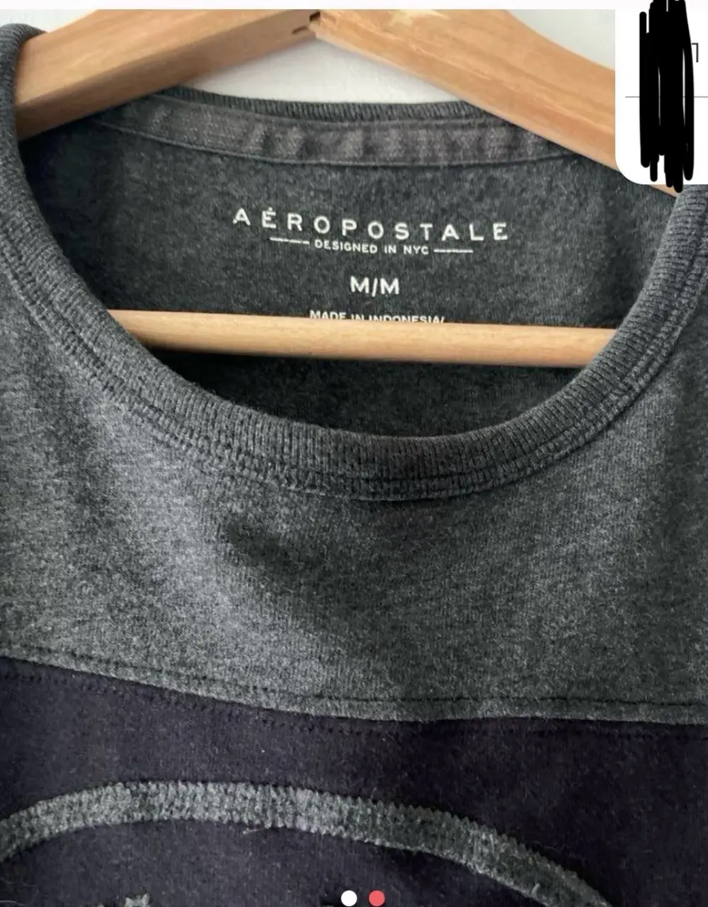 Remera de hombre Aeropostale, diseño bicolor en gris y negro. Con estampado circular "New York 1987 Aero-U.S.". Ideal para un look casual y urbano.