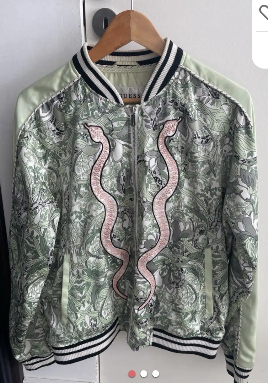 Campera bomber Guess con estampado floral y detalles de serpientes. Ideal para un look casual y con estilo.