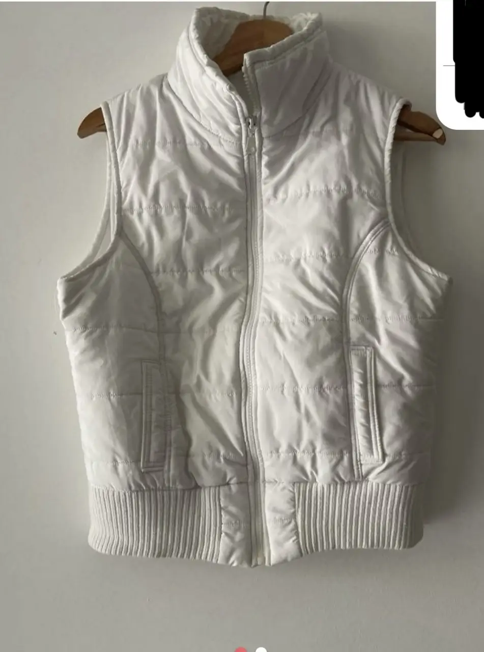 Chaleco blanco acolchado, ideal para el invierno. Con cierre y bolsillos.