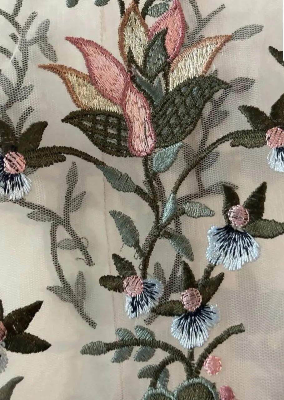 Blusa de gasa bordada con flores en tonos pastel. Ideal para un look romántico y delicado. Perfecta para combinar con jeans o falda.