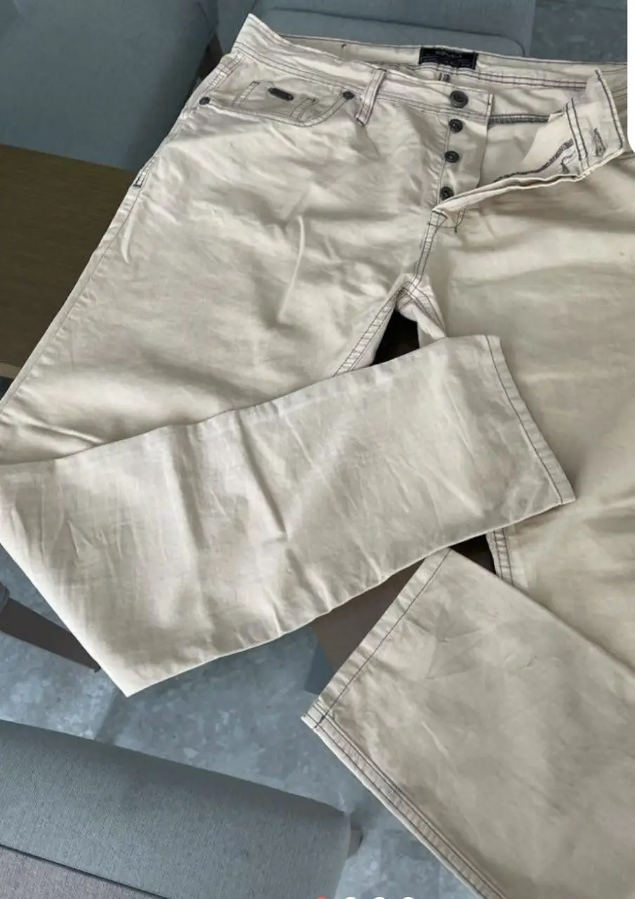 Pantalón chino color crudo para hombre, con cierre de botones y detalles de costura en contraste. Marca Bowen.