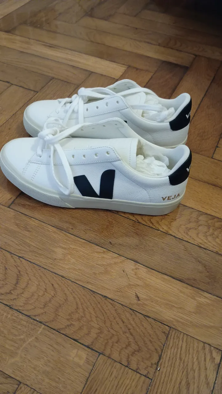 Zapatillas Veja blancas con el logo en negro. Nuevas sin estrenar. Tienen cordones blancos y suela de goma. Ideales para un look casual y cómodo.