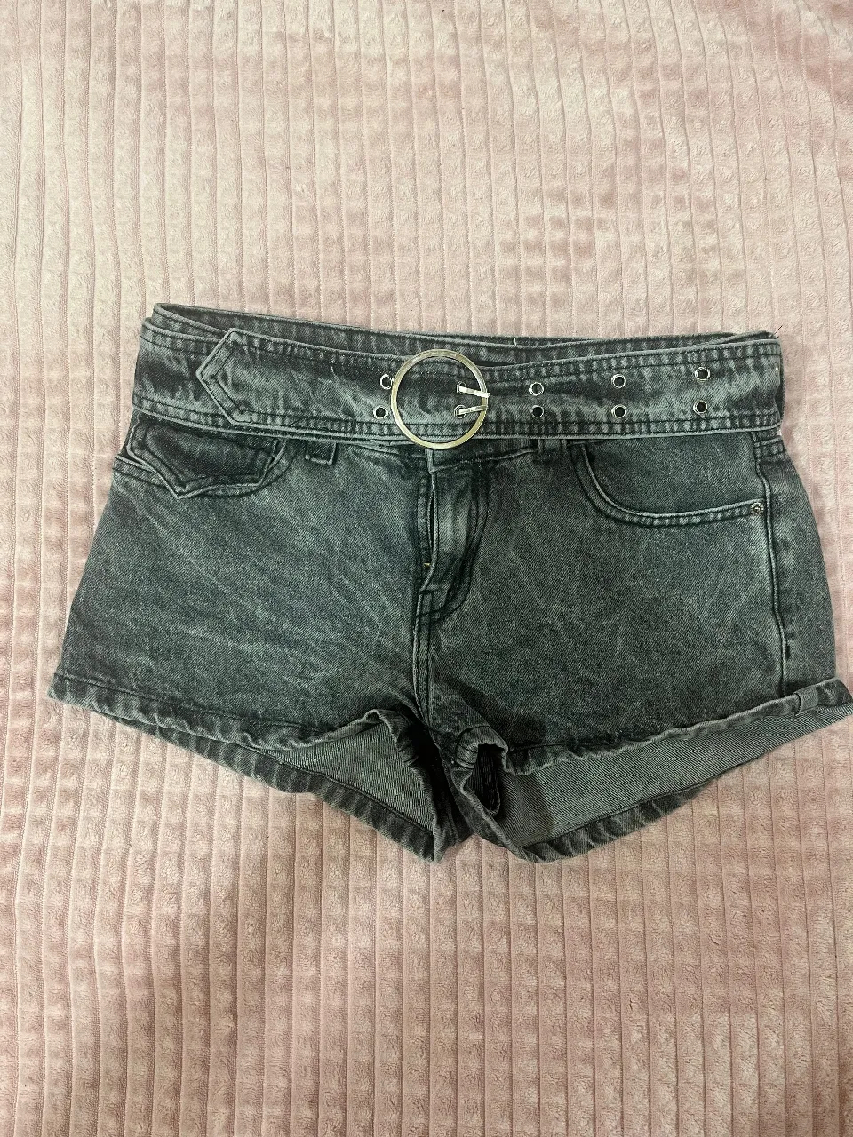 Shorts de jean tiro bajo con cinto incluido. Lavado gris oscuro con detalles desgastados. Ideales para un look canchero y moderno.