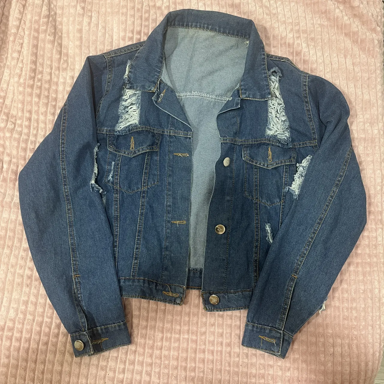 Campera de jean de mujer, tiro corto, con roturas y desgastes. Un clásico que no puede faltar en tu guardarropa, ideal para darle un toque canchero a cualquier outfit.