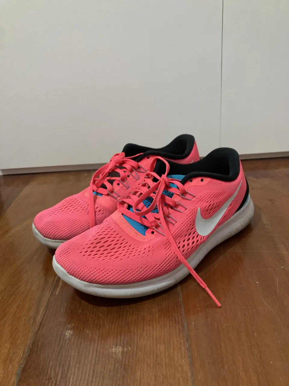 Zapatillas deportivas Nike Free RN color rosa vibrante con detalles en azul y blanco. Ideales para running o para un look casual y cómodo. ¡Perfectas para tus entrenamientos o para el día a día!