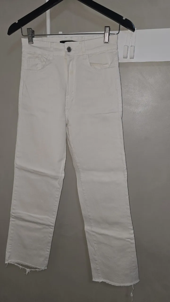 Jeans blancos tiro alto con roturas en los bajos. Un básico canchero para tu día a día.