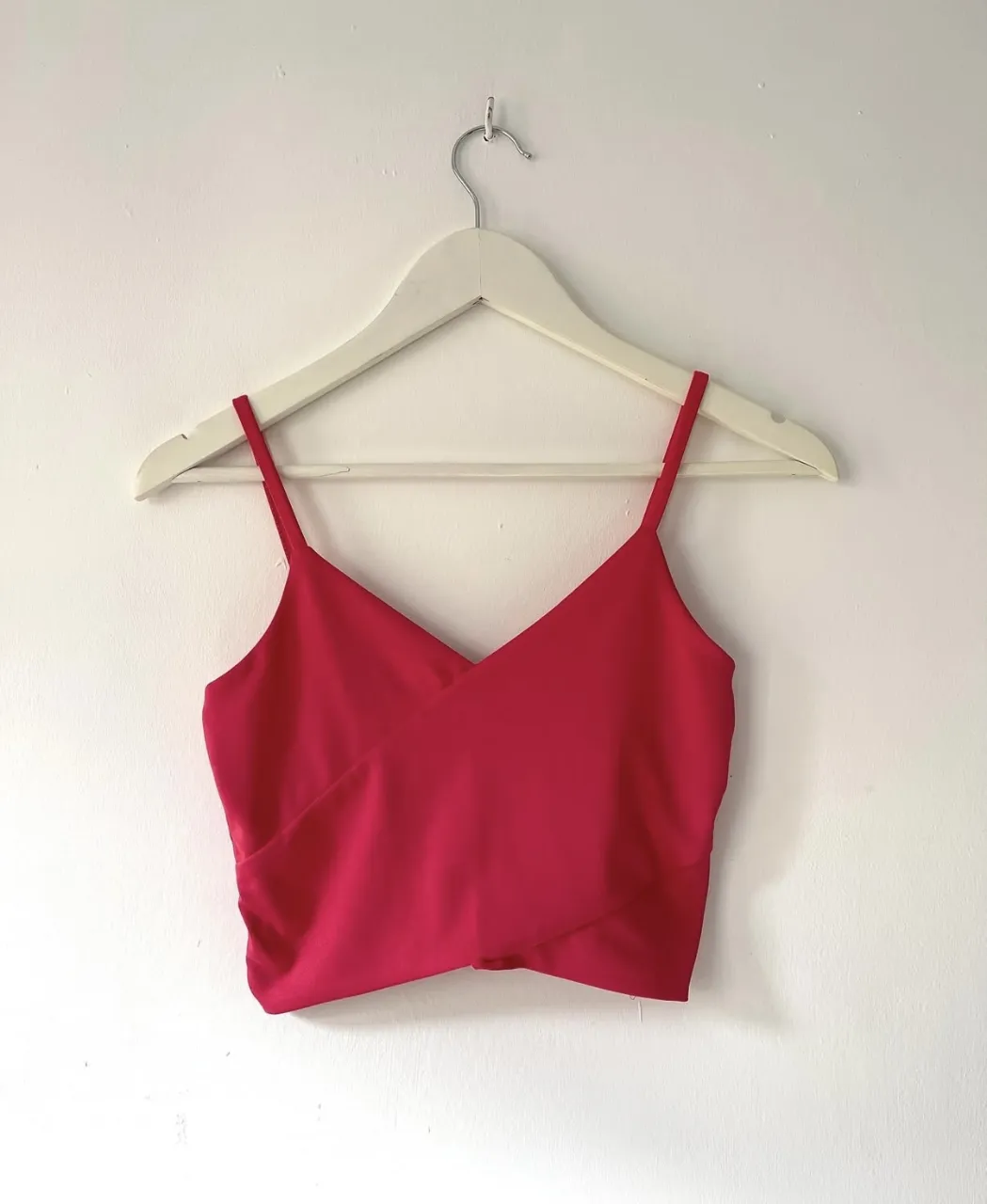 Top fucsia con breteles finos y escote en V cruzado. 