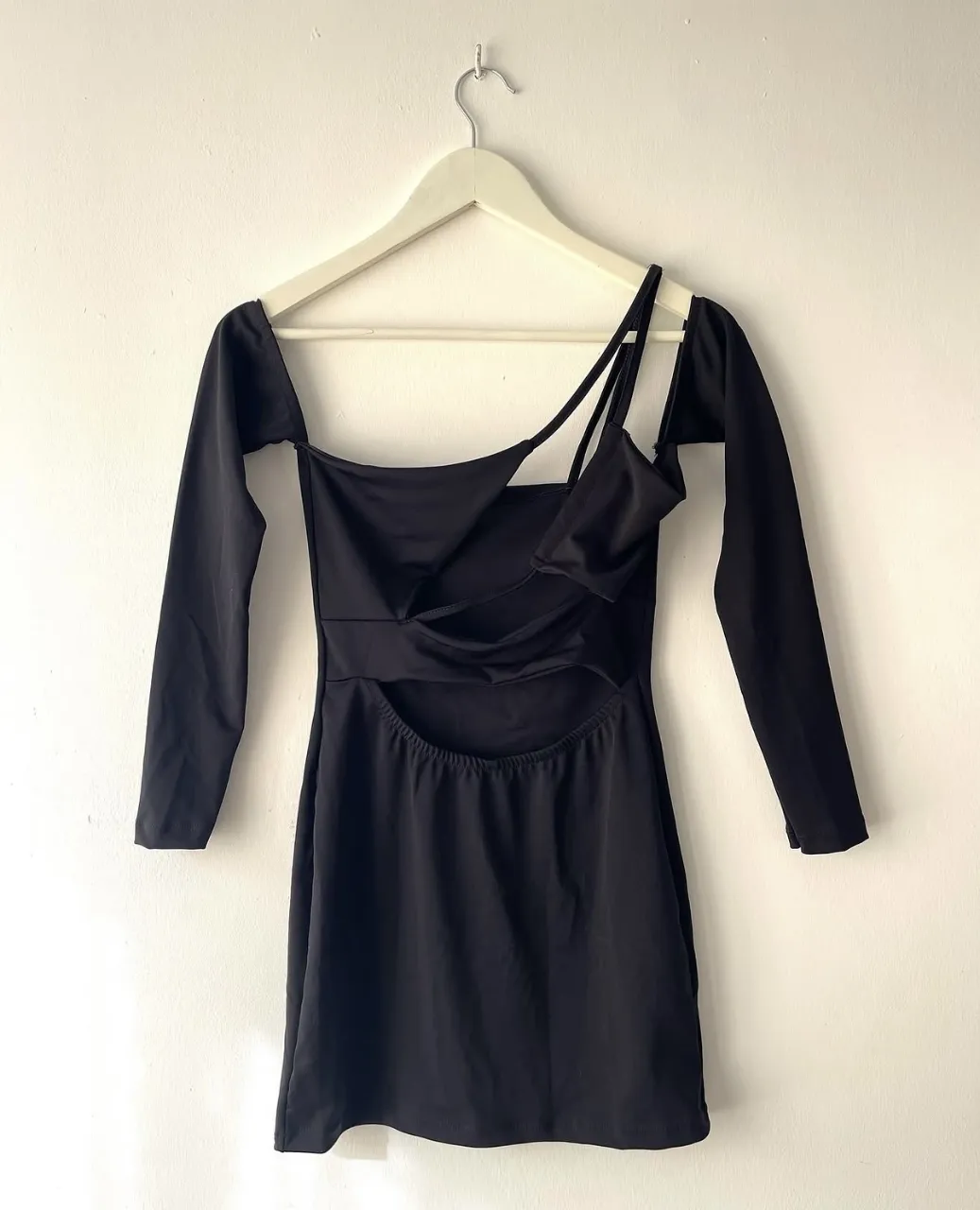 Vestido negro, con un diseño cut-out en frente y mangas. 