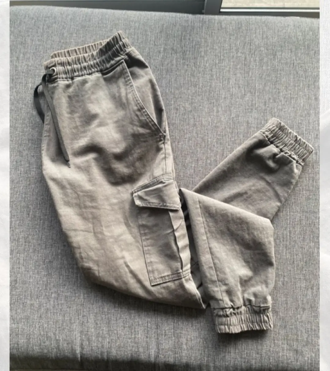 Pantalón cargo de hombre, color verde oliva claro con bolsillos laterales y ajuste en los tobillos. Ideal para un look casual y cómodo.