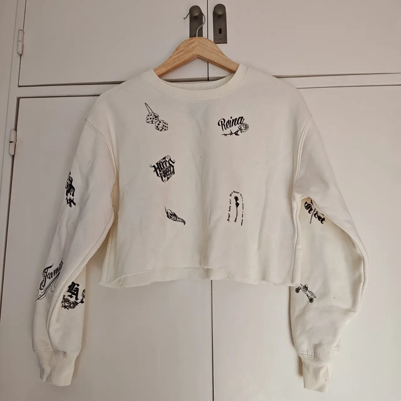 Buzo crop natural con estampados de Hot Wheels y otros diseños. Ideal para un look casual y moderno.