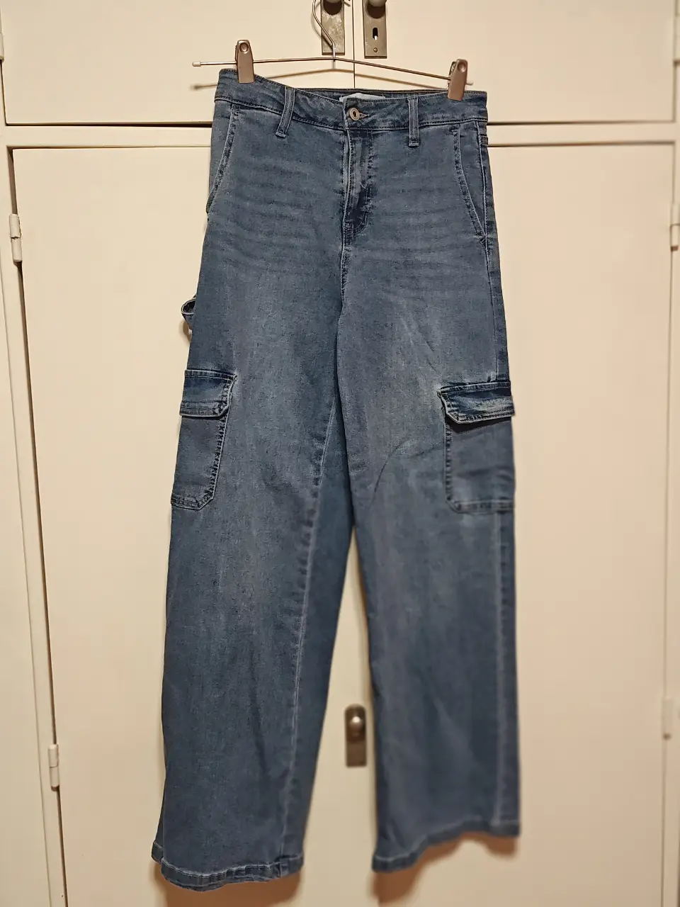 Pantalón cargo de jean azul, tiro alto, con bolsillos laterales y traseros. Ideal para un look casual y cómodo.