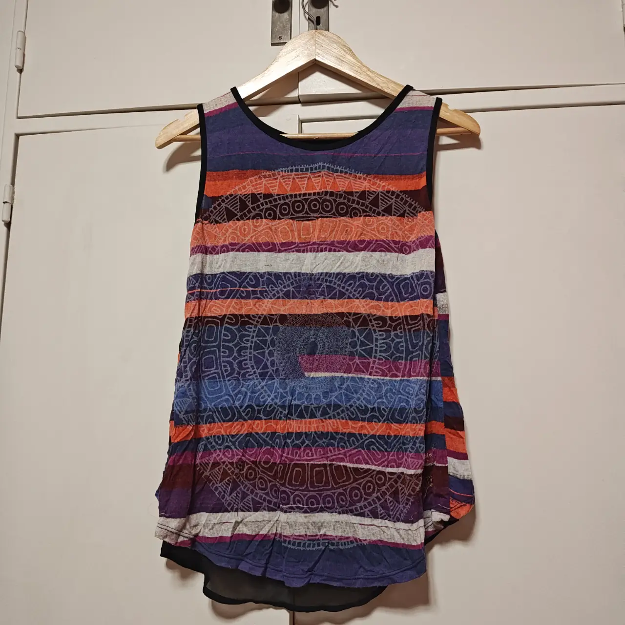 Musculosa de mujer con diseño estampado a rayas y detalles circulares. Posee espalda cruzada y un gasa negra. Ideal para un look casual y fresco.