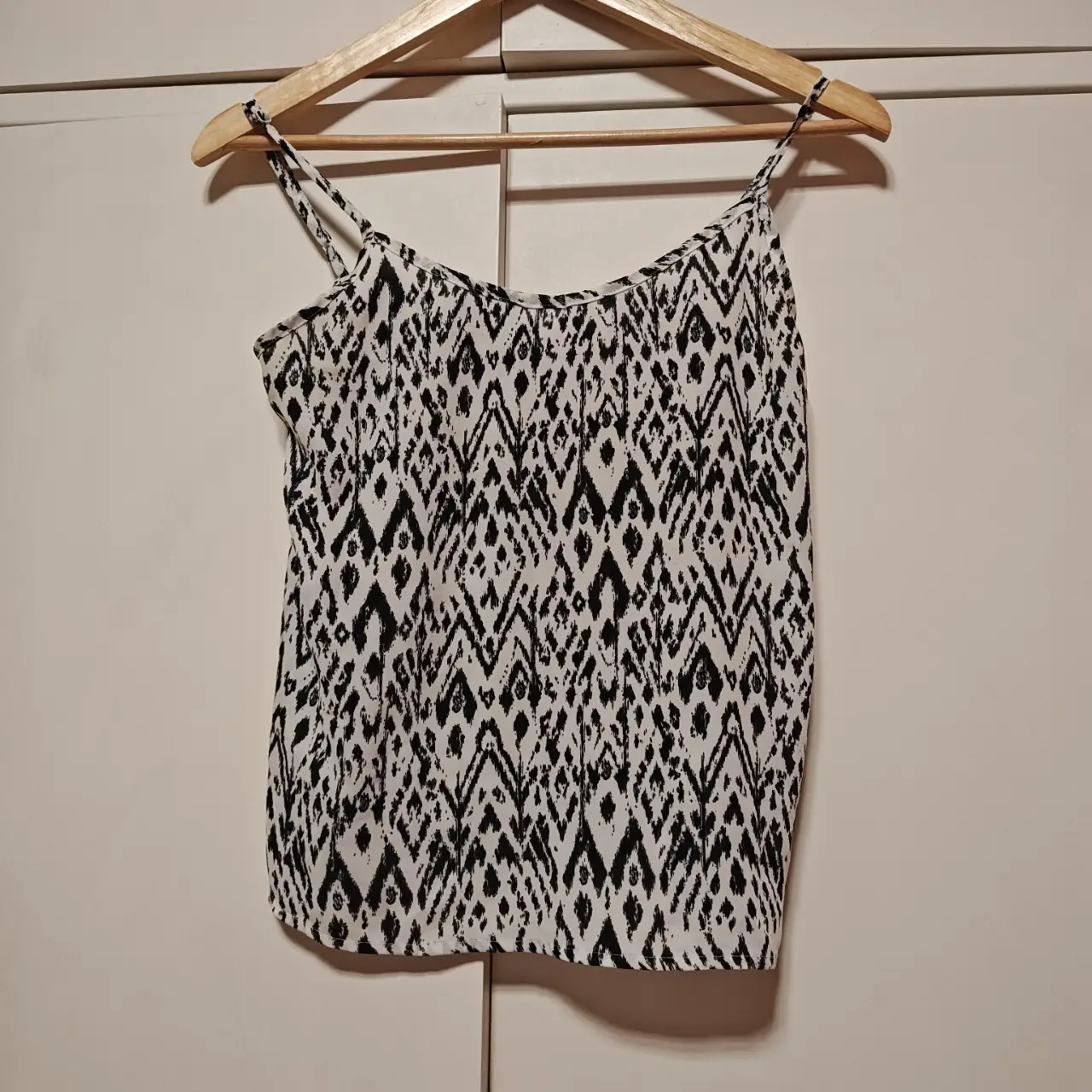 Top de mujer con estampado geométrico en blanco y negro. Ideal para un look casual y fresco.
