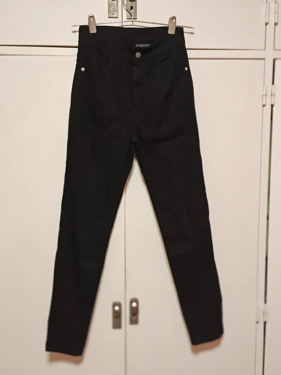Jeans chupin negros de mujer, tiro medio, con etiqueta de la marca Striven. Talle 36.