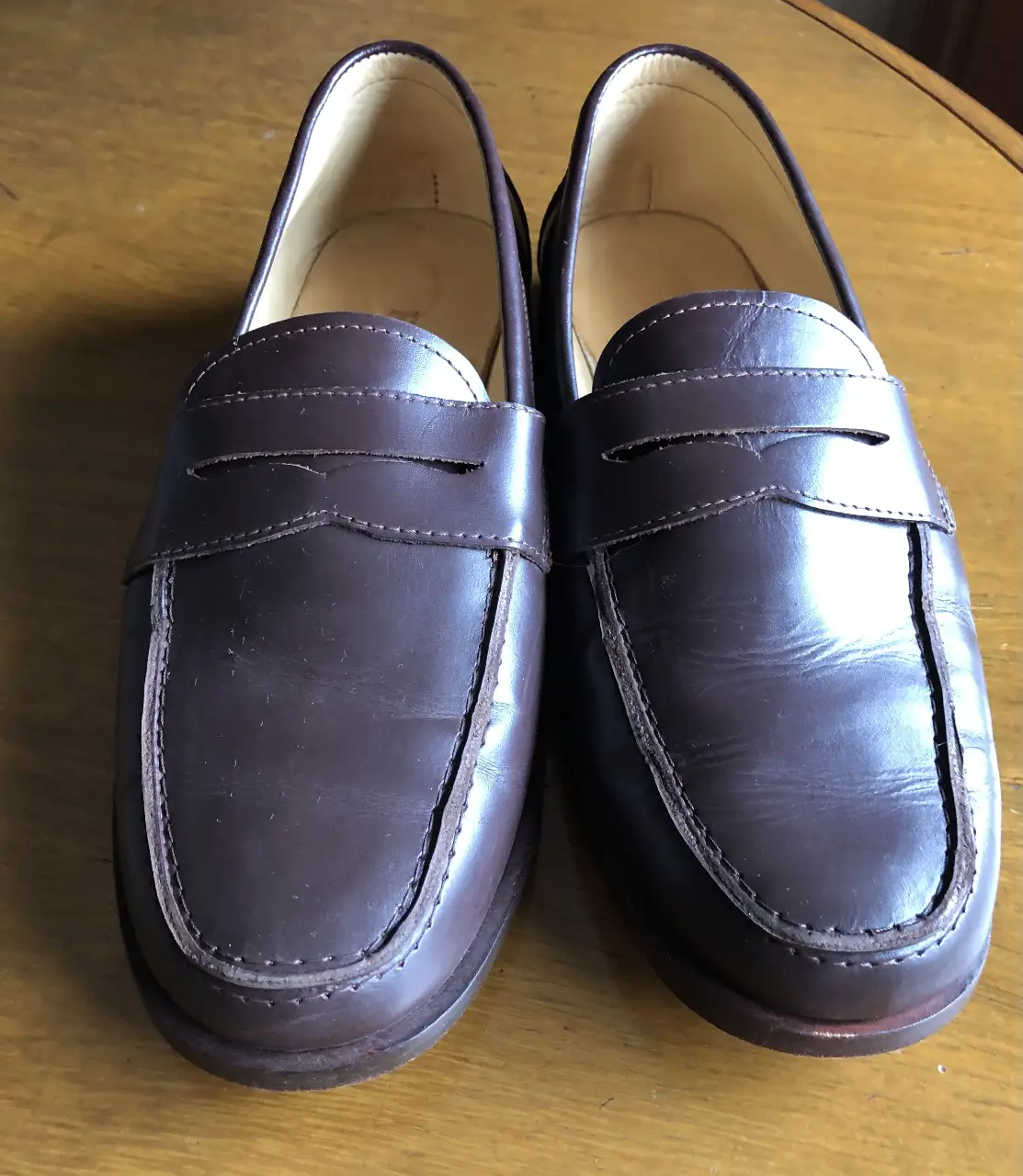 Mocasines de cuero marrón oscuro para hombre, ideales para un look casual y elegante. Diseño clásico con detalles de costura y ajuste cómodo.