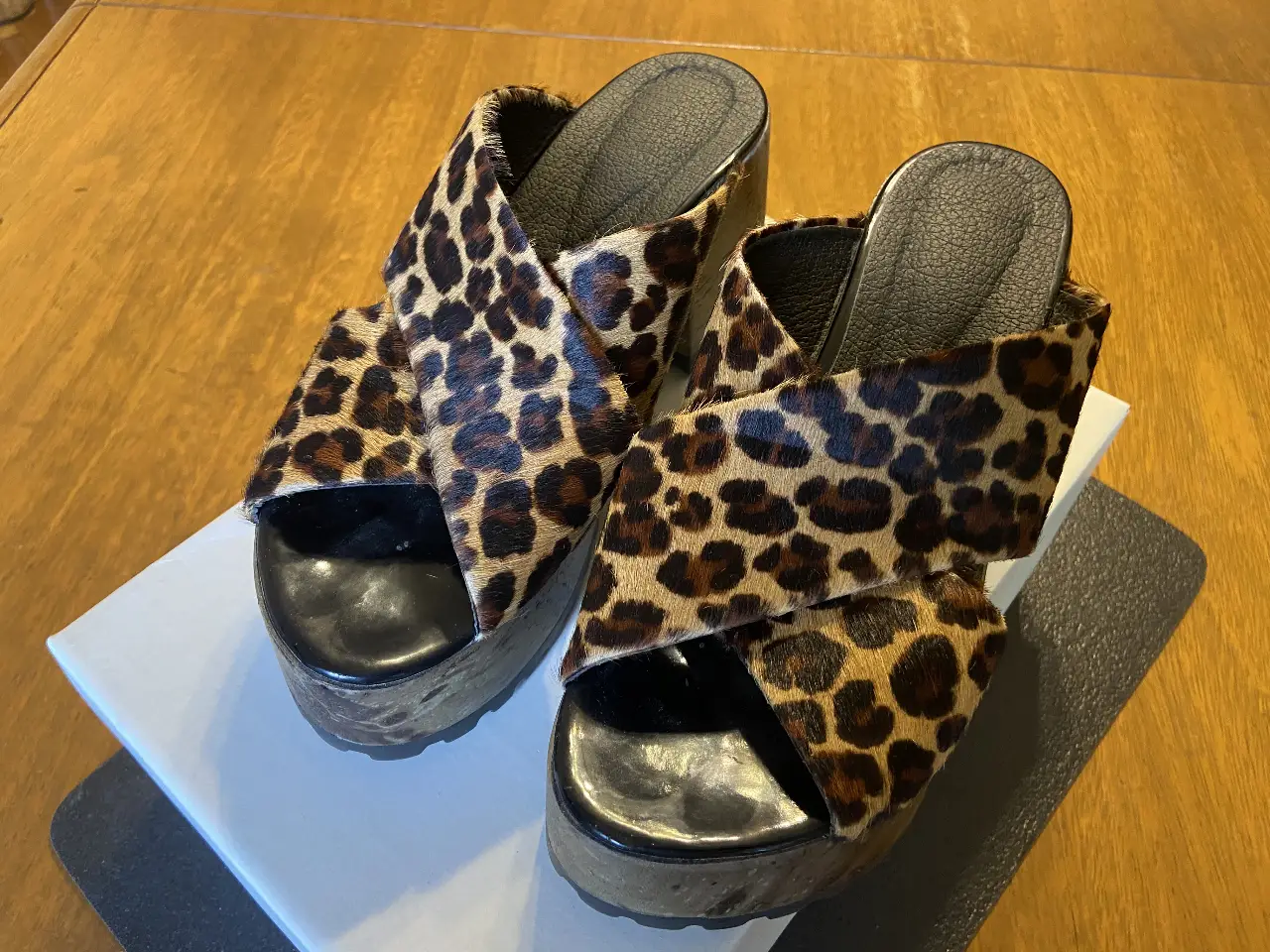 Sandalias de cuero animal print. Diseño con tiras cruzadas y plataforma de madera. Ideales para un look audaz y moderno.