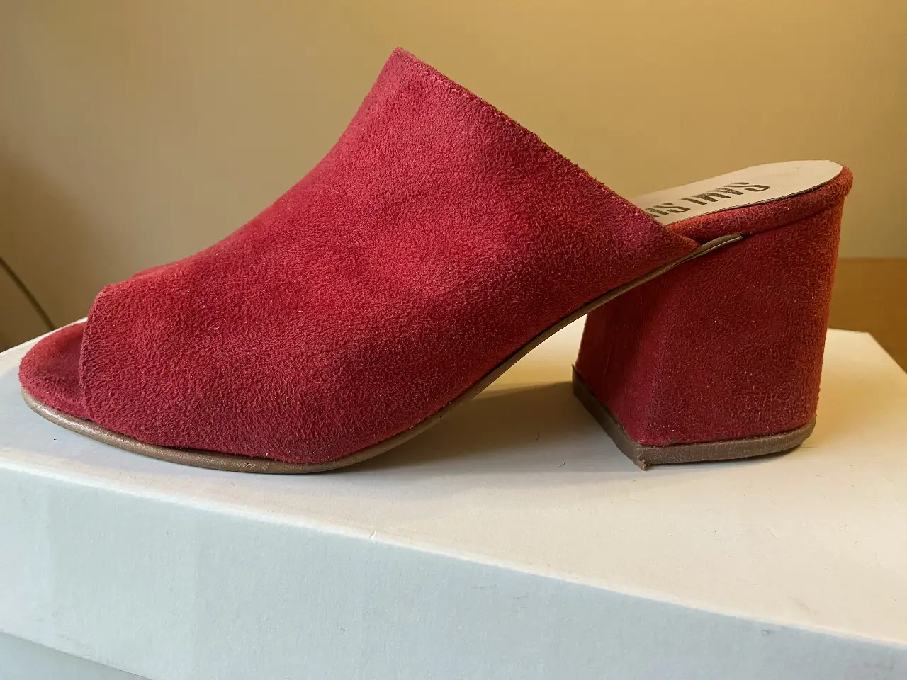 Sandalias rojas de gamuza con taco ancho y punta abierta. Ideales para un look moderno y cómodo.