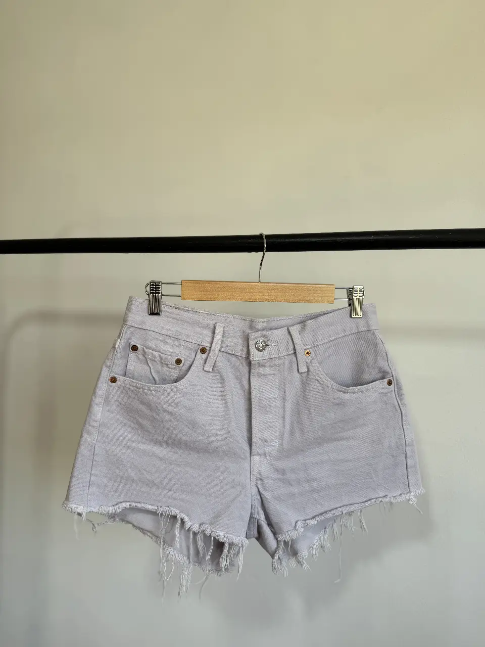 Short de jean color lila con flecos en el borde. Tiro medio, ideal para un look casual y relajado. Perfecto para el verano.