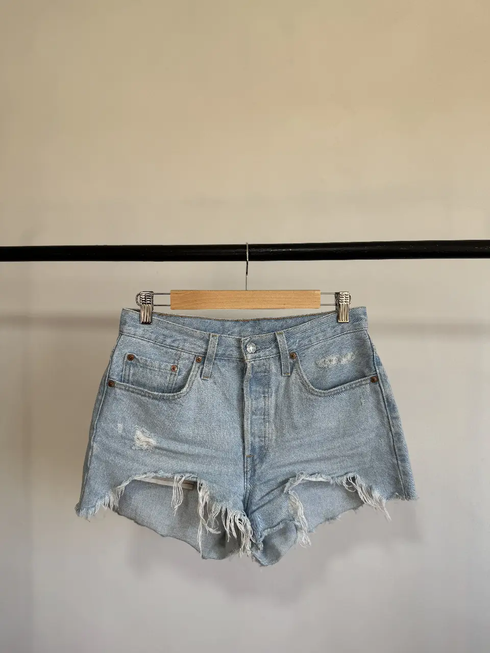 Short de jean de mujer, tiro medio, con roturas y desflecado en el borde. Ideal para un look casual y relajado.