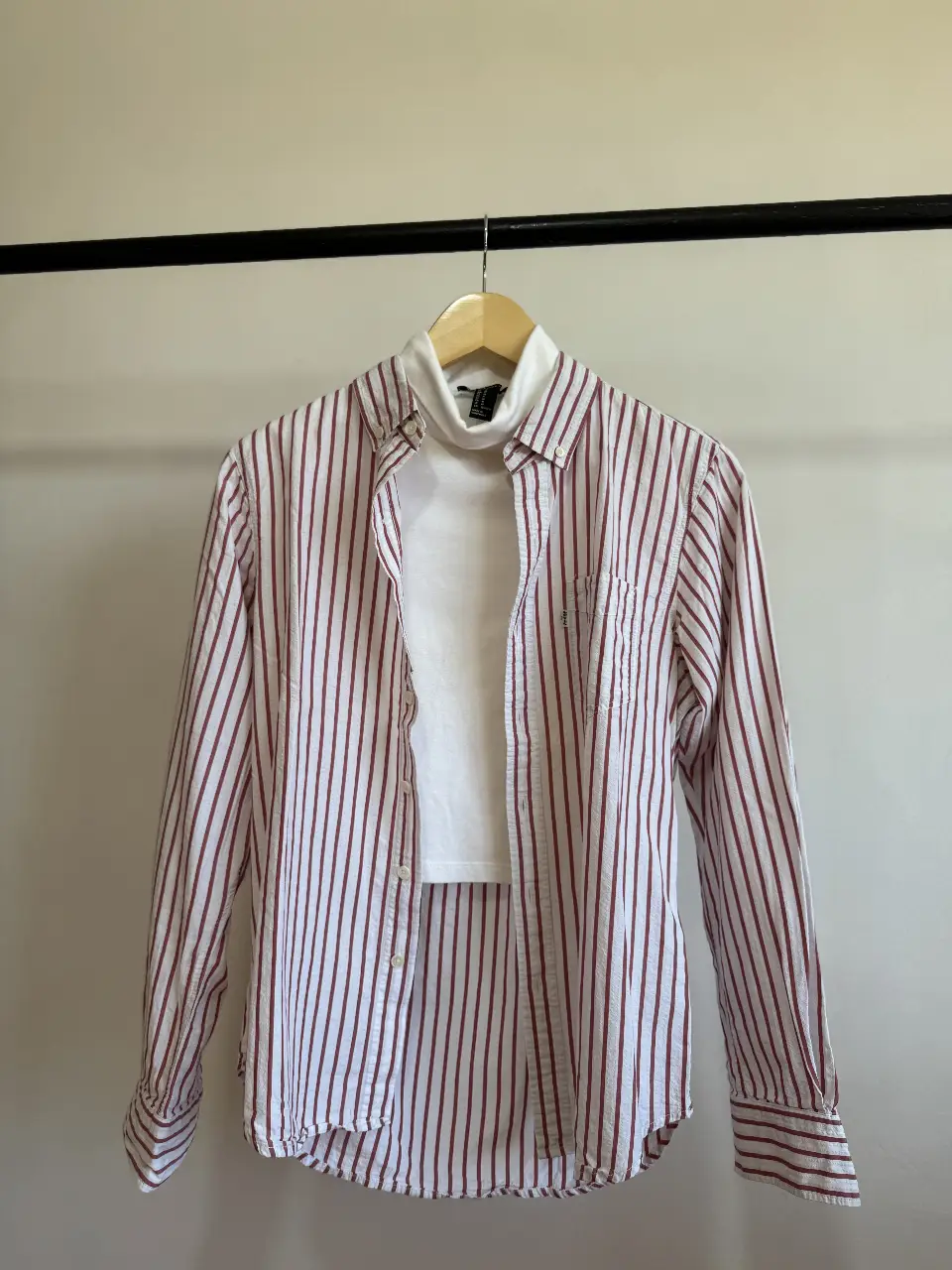 Camisa a rayas rojas y blancas de la marca Levi's. Corte slim fit, con bolsillo en el pecho y cuello clásico. Ideal para un look casual y moderno.