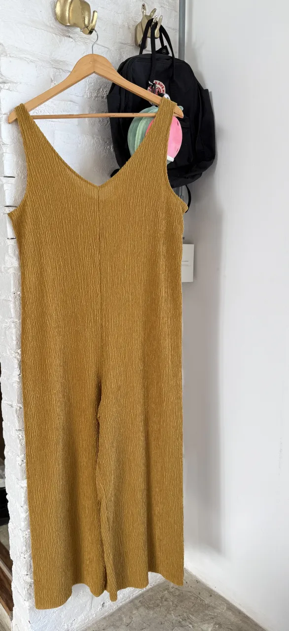 Mono largo de color amarillo mostaza. Posee un tejido texturizado con finas líneas verticales.