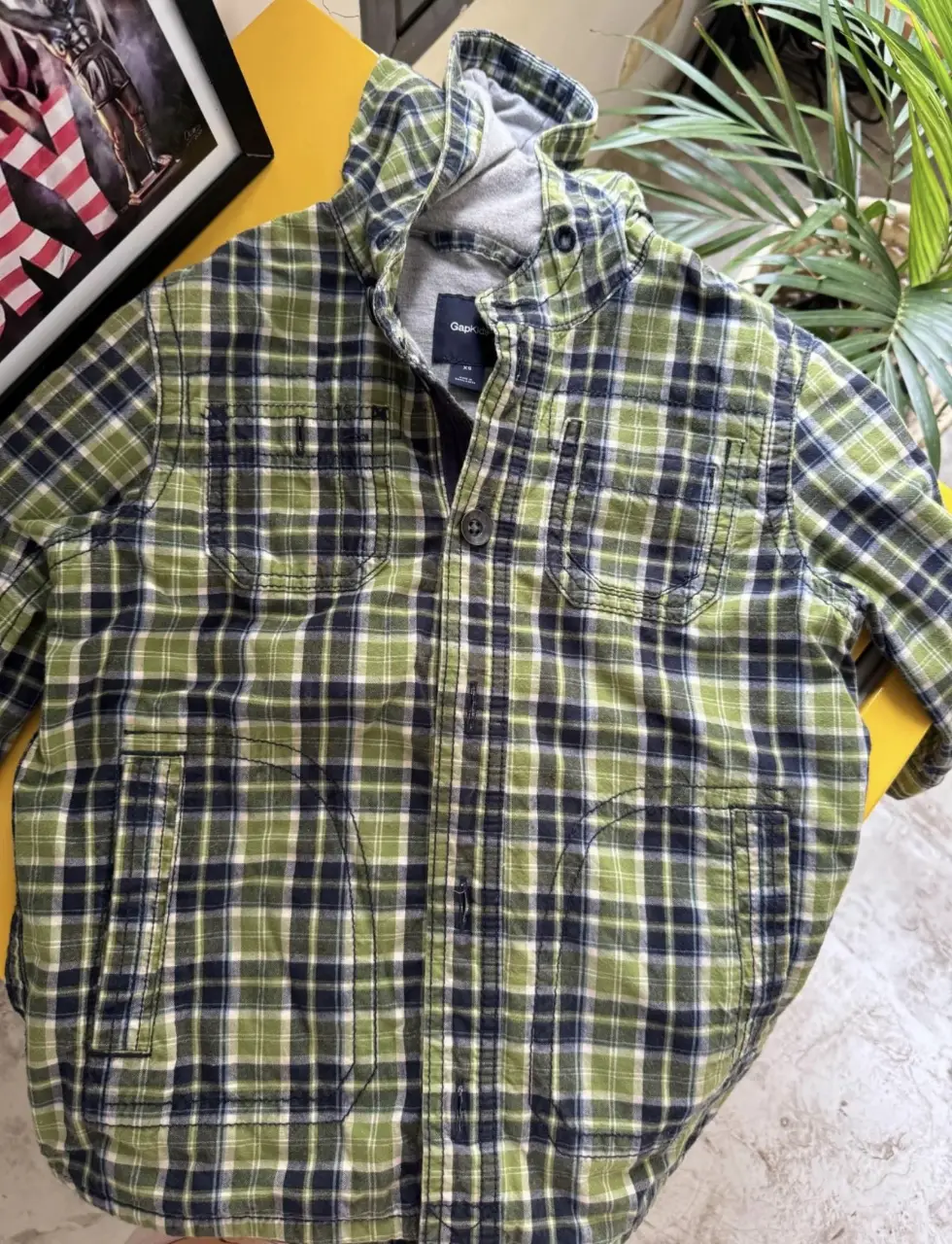 Camisa a cuadros para niño, con capucha de color gris. Posee cierre y dos bolsillos delanteros. Ideal para un look casual y abrigado. baby gap 8 años