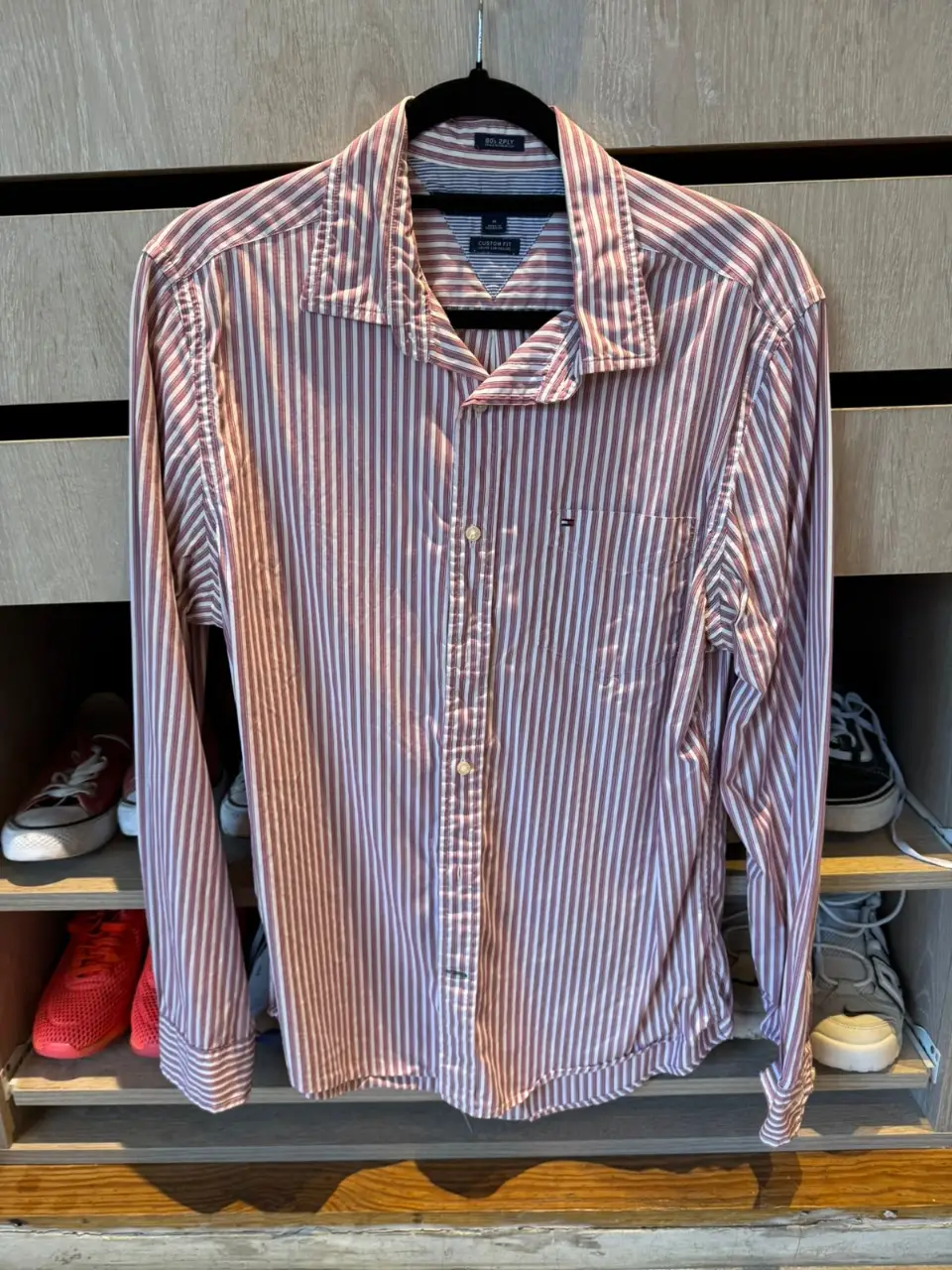 Camisa a rayas rojas y blancas de hombre, con cuello y bolsillo en el pecho. Ideal para un look casual y moderno.