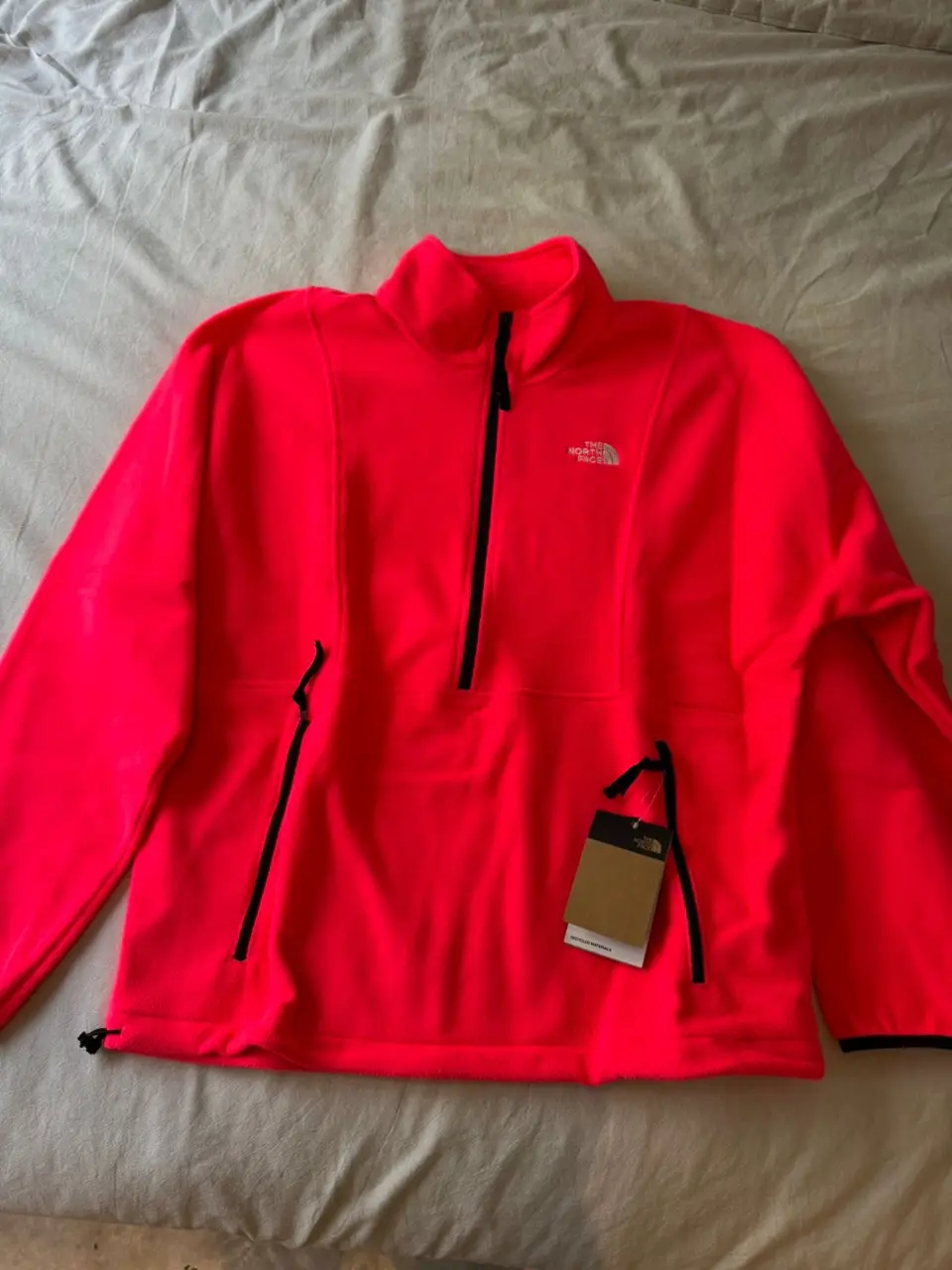 Buzo con cierre The North Face para hombre, color rojo neón. Confeccionado con materiales reciclados, ideal para actividades deportivas y uso casual. Talle L.