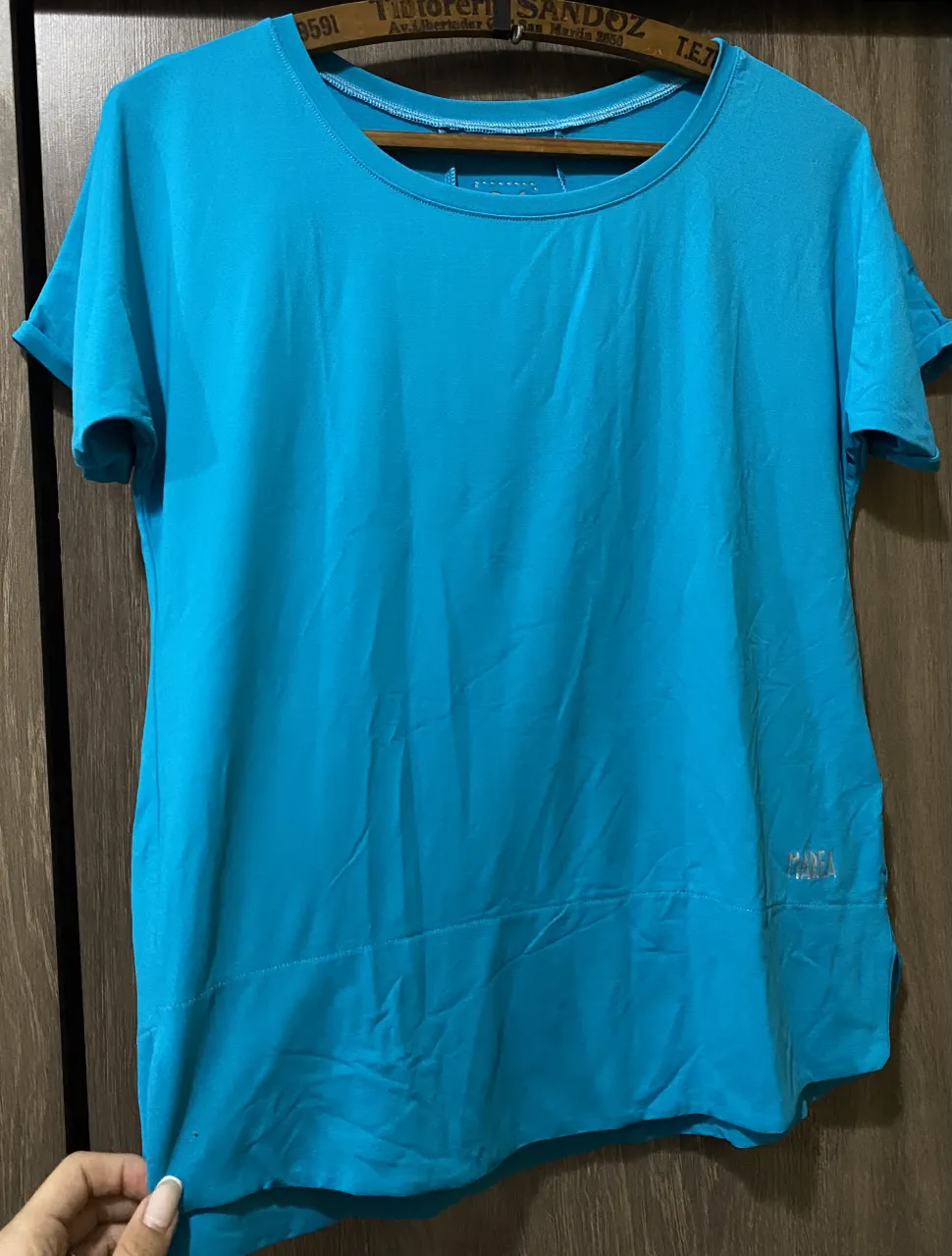 Remera deportiva color azul. Tiene cuello redondo y mangas cortas con dobladillo.